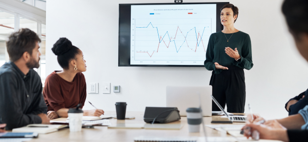 Profissionais em reunião estratégica, analisando dados de desempenho com foco em resultados e tomada de decisão.