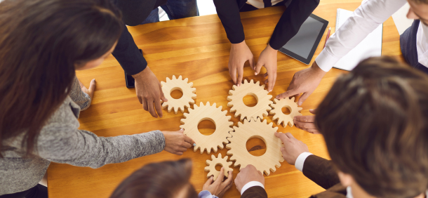 gestão de equipes, com profissionais conectando engrenagens, representando colaboração, integração de talentos e trabalho em sincronia.