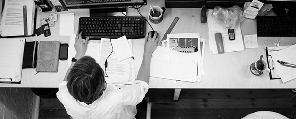 performance, homem trabalhando em seu escritório de frente com o computador, papeis a mesa