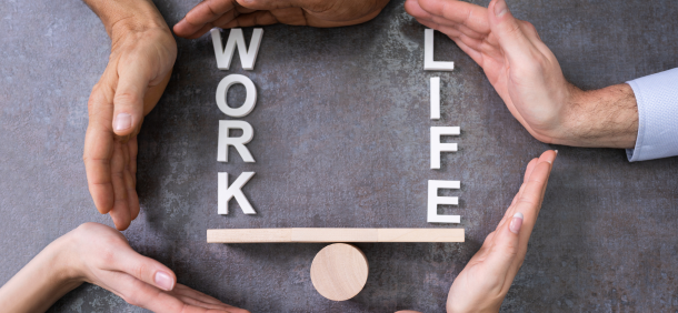mãos ao redor de madeira em forma de equilibrio acima escrito work e life