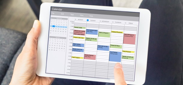pessoa utilizando um tablet para visualizar uma agenda semanal detalhada e organizada demonstrando planejamento e controle das atividades