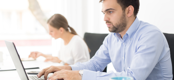 Profissional concentrado em frente ao computador, representando disciplina no trabalho