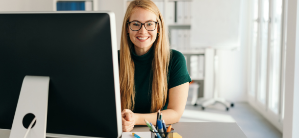Profissional sorridente em ambiente corporativo, simbolizando o desenvolvimento pessoal e profissional com confiança e organização
