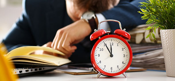 falta de tempo, despertador vermelho, funcionário de escritório cansado de terno tirando uma soneca na mesa de trabalho cheio de papéis