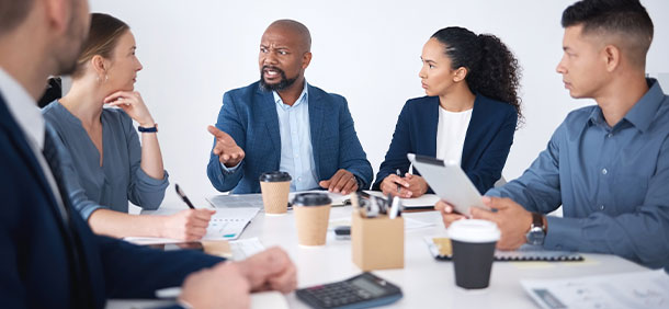 pessoas reunida em sala de reunião conversando sobre planejamento de trabalho