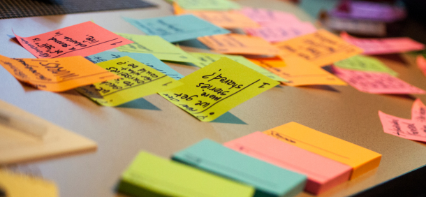 Post-its coloridos sobre a mesa representando planejamento e organização visual de tarefas.