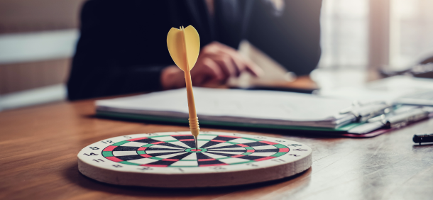 Alvo de dardos sobre a mesa com pessoa ao fundo
